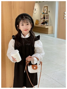 Détail d'une élégante robe noire et blanche pour fille avec volants et manches lanternes