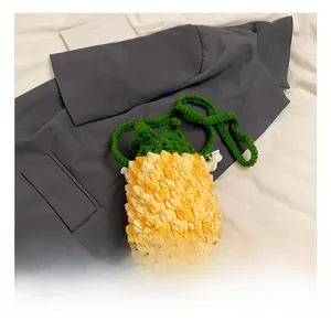 Detailed view of handmade crochet pineapple shoulder bag with green leaves and strap