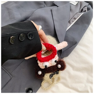 Close-up of handmade crochet sausage mouth bag with pearl details and a cute bow