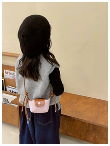 Détail d'un mini sac bandoulière rose avec rabat marron et sangle réglable enfant