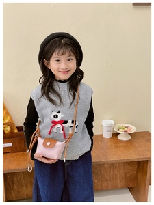 Détail du mini sac bandoulière enfant en cuir rose avec rabat marron et sangle nouée