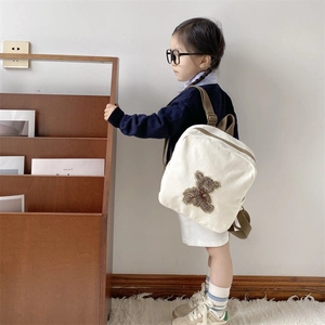 Cute beige canvas toddler backpack with cartoon bear patch and brown straps for kids