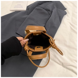 Detail view of the magnetic closure and brown interior lining of this leather handbag