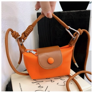 Détail du mini sac bandoulière orange et marron avec sangle en corde et crochets métal