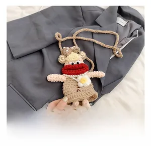 Detail of a handmade crochet doll shoulder bag with a red scarf and a long woven strap