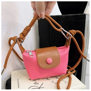 Détail du mini sac à bandoulière en cuir rose avec rabat marron et sangle tressée