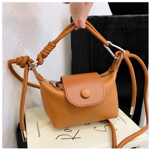 Détail du mini sac bandoulière caramel avec texture litchi et sangle tressée
