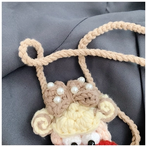 Close-up of handmade crochet animal bag featuring knitted texture and pearl accents