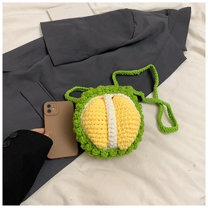 Detail of a handmade crochet durian shoulder bag with green spiked texture and yellow pulp