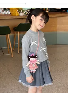 Detail of child wearing a handmade crochet doll shoulder bag with cute sausage lips