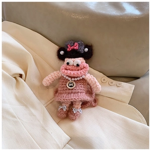 Detail of pink knitted doll bag with sausage lips, pearl necklace and bow accents
