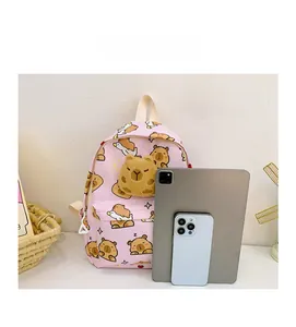 Sac à dos rose capybara pour enfants présenté à côté d'une tablette pour l'échelle