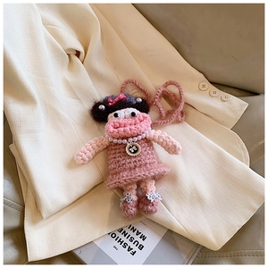 Detail of pink crochet cartoon girl shoulder bag with pearls on a blazer background