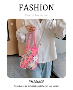 Detail of crochet daisy handbag with pearl chain strap on model in white shirt