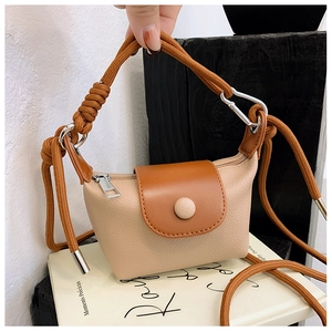 Détail d'un mini sac bandoulière en cuir beige avec rabat marron pour enfants