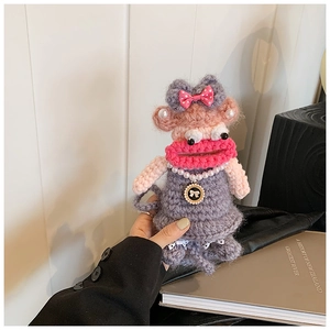 Detail of handmade crochet shoulder bag featuring pearl necklace and pink bow accents