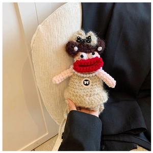 Detailed close-up of handmade crochet doll bag with red lips and pearl necklace
