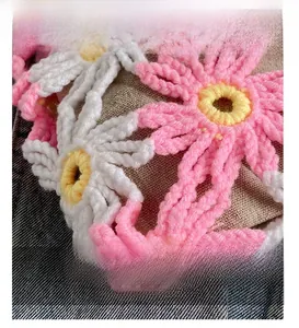 Close-up of handmade 3D crochet flowers and fabric texture on a women's handbag