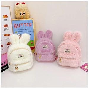 Détail des sacs à dos en peluche avec oreilles de lapin en blanc crème, violet clair et rose