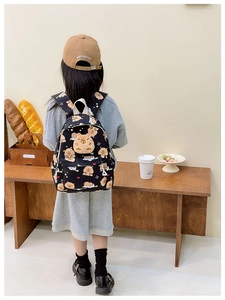 Détail d'un enfant portant un sac à dos noir avec motifs de capybara mignons et cœurs colorés