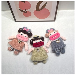 Detailed close-up of three handmade crochet doll bag charms with funny thick lips