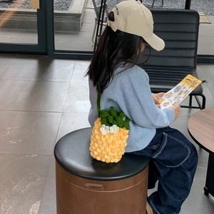 Handmade crochet pineapple bucket bag for kids with green leaves and white flowers