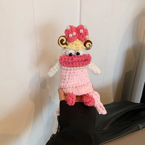 Close-up of handmade crochet doll coin purse with pink lips and pearl bow detail