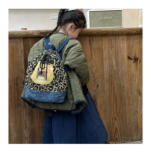 Vue de dos d'un enfant portant un sac à dos en toile imprimé léopard avec patch chat