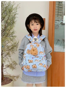 Détail de l'imprimé capybara mignon et de l'ornement en peluche du sac à dos enfant