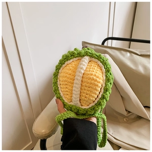 Detail of a handmade crochet durian crossbody bag being held to show mini size