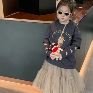Toddler girl two-piece outfit with grey cartoon top, beige tutu skirt and crochet bag