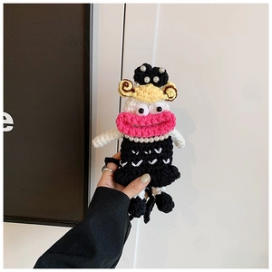 Macro view of handmade crochet doll coin purse with big lips and pearl dress detail