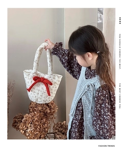 Quilted cotton floral handbag for kids featuring a large red knitted bow detail