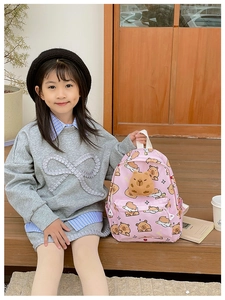 Détail du sac à dos rose pour enfants avec motifs capybara et breloque en peluche