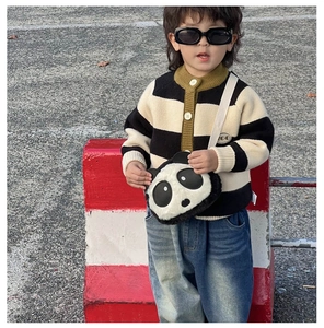Close-up of cute panda plush crossbody bag styled with trendy kid's striped cardigan and sunglasses