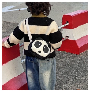 Detail view of the plush panda shoulder bag with adjustable woven strap on a child