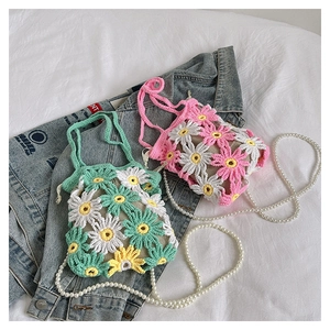 Detailed knit of handmade daisy crochet bag with floral patterns and pearl strap accents