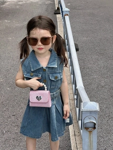 Détail du sac à main cœur à paillettes roses avec anse perle et boucle logo CD sur robe