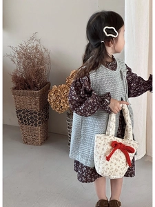 Macro shot of cream floral quilted handbag with red ribbon bows for girls fashion