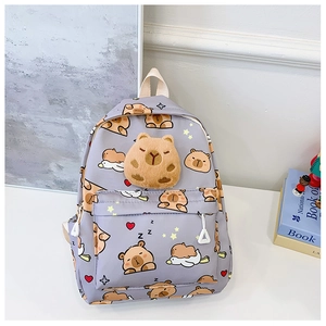 Détail d'un sac à dos gris pour enfant avec capybara en peluche 3D et motifs animés