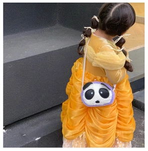 Detail of cute panda plush bag with purple trim and pearl buckle on a yellow dress