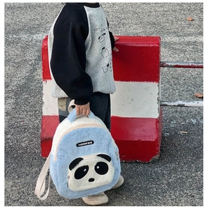 Detail of plush panda backpack showing blue faux fur texture and cute 3D panda face pocket