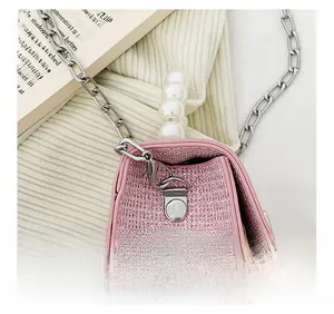 Détail du fermoir en métal argenté et texture pailletée rose sur le sac perle fille