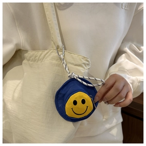 Detailansicht einer blauen Mini-Smiley-Geldbörse mit Karabiner an einer Canvas-Tasche