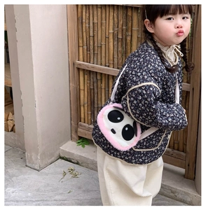 Close-up of child wearing a panda plush crossbody bag with blue floral fabric detail