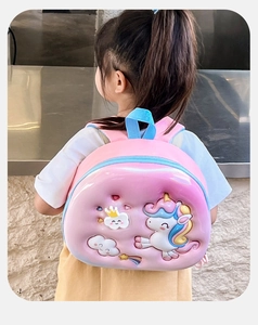 Detail of pink hard-shell backpack for kids featuring 3D unicorn and rainbow designs