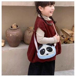 Detail view of a cute panda plush crossbody bag with soft blue fur on a child model