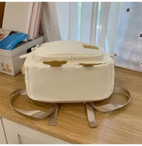Close-up of cream backpack with yellow chicken ear details and front flap pocket