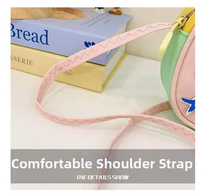 Détail de la bandoulière rose avec coutures en zigzag renforcées sur le sac enfant