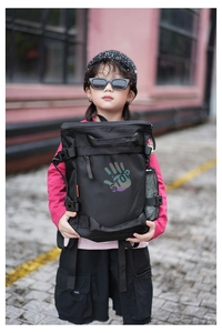 Detailed view of kids black nylon backpack with STOP print and reflective palm graphic